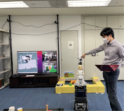 写真２　ガーディアンロボット 試作機第１号「ぶつくさ君」の実験の様子 吉野チームリーダー（NISTEP撮影）